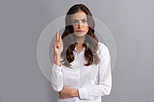 Frown woman executive manager keep finger pointing up grey background, idea