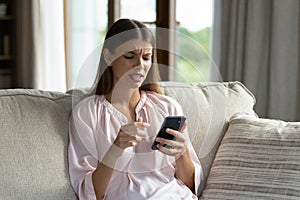 Frown woman holds smartphone feels dissatisfied due to broken device