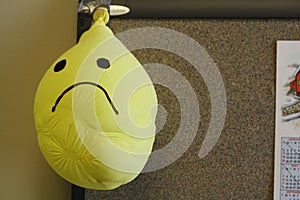 Frowning sad face smiley face yellow balloon deflated