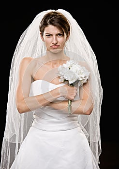 Frowning young bride in wedding dress and veil