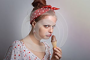 Frowning young Caucasian woman girl holding ice cream looks grumpy as if doesn`t want to  share or angry, annoyed
