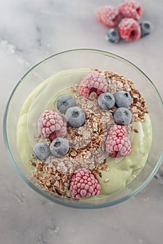 Frozen avocado smoothie bowl with frozen berries