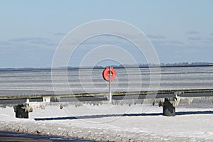 Frozen Baltic Sea and bridge with red life buoy