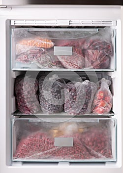 Frozen berries in transparent plastic bags in the freezer