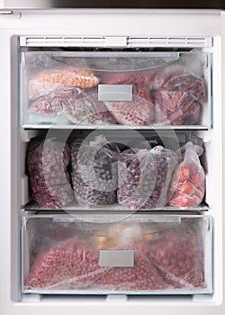 Frozen berries in transparent plastic bags in the freezer photo