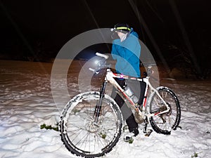 Frozen boy breathes into cold palms of his wet gloves. Crazy biking