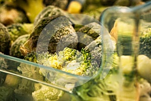 frozen broccoli florets and brussel sprouts inside freezer fridge closeup