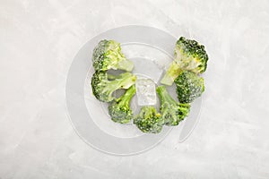 Frozen broccoli and ice cubes on kitchen table. Freezing is a safe method to increase the shelf life of nutritious foods. Reserve