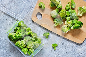 Frozen broccoli in lunch box on a concrete background