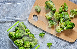 Frozen broccoli in lunch box on a concrete background