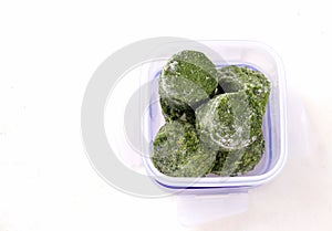 frozen broccoli in lunch box on a white background