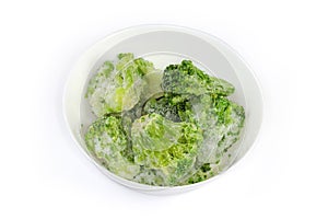 Frozen broccoli in white bowl on a white background photo