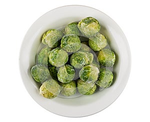 Frozen brussels sprouts in glass plate isolated on white background