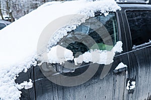 Frozen car covered with snow on a winter day