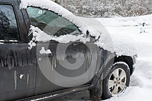 Frozen car covered with snow on a winter day