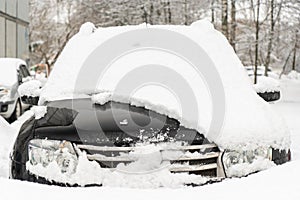 Frozen car covered with snow on a winter day