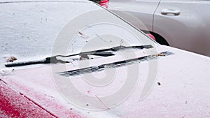 Frozen car covered snow at winter day, view front window windshield and hood.