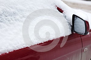 Frozen car covered snow in winter day, view front window windshield and hood on snowy background .