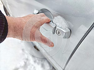 Frozen Car Lock on a Cold Winter Day. Woman person attempts to unlock a frozen car door. Problem during trip and travel