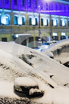 Frozen car during night snowfall