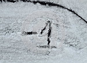 Frozen car window with text -1 scratched into ice