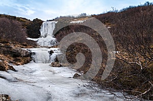 Frozen cascading waterfall from the meltwaters of Icelandic glaciers photo