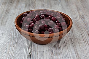 Frozen cherries in a clay bowl on a wooden table