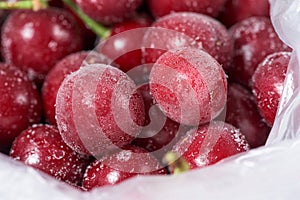 Frozen cherries are covered with ice crystals and frost for winter home preparation in the freezer