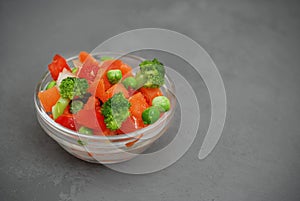 Frozen Colorful Vegan Healthy Vegetables. Brocolli, Carrots, Peas, Pepper. vertical Image. Gray Background.