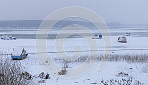 Frozen Danube on ice with five small fishing boats