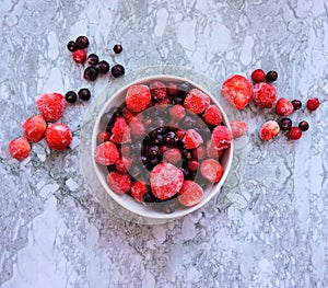 Frozen delicious berries on blue background, closeup.