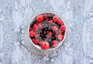 Frozen delicious berries on blue background, closeup.