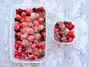 Frozen delicious berries on blue background, closeup.