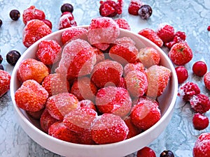 Frozen delicious berries on blue background, closeup.