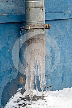 Frozen downpipe. Icicles from the downspout