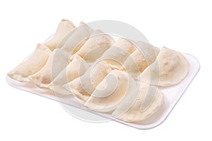 Frozen dumplings in a tray in rows on a white background