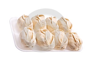 Frozen dumplings in a tray in rows on a white background