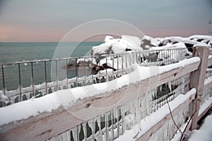 Frozen fence covered in icicles overlooking Lake Michigan in winter