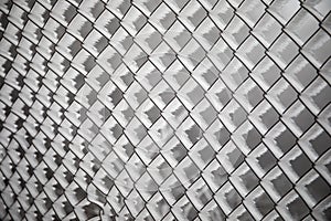 Frozen fence made of metal mesh covered with frost crystals, an early sunny cold morning, on a blurred background