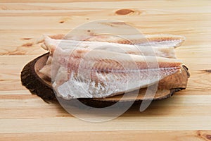 Frozen fillet of pangasius on wooden plate