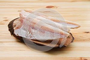 Frozen fillet of pangasius on wooden plate