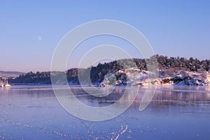 Frozen fjord in the evening with moon