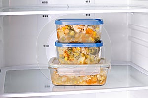 Frozen food in a container in the freezer. Ready meal. Refrigerator with frozen food