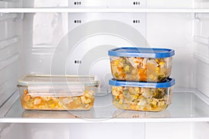 Frozen food in a container in the freezer. Ready meal. Refrigerator with frozen food