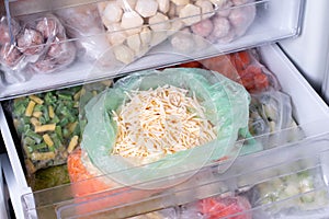 Frozen food in the freezer. Frozen grated cheese