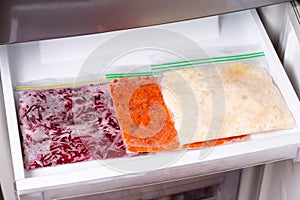 Frozen food in the refrigerator. Vegetables on the freezer shelves