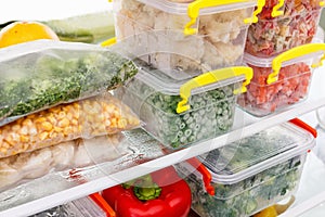 Frozen food in the refrigerator. Vegetables on the freezer shelves.