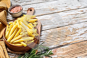 Frozen French fries in a bowl, organic vegetables. White wooden background. Top view. Copy space