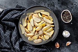 Frozen French Fries potato wedges. Black background. Top view