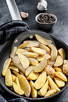 Frozen French Fries potato wedges. Black background. Top view